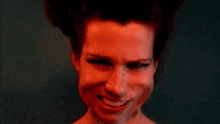 a close up of a woman 's face with red hair making a funny face