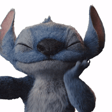 a stuffed animal with its eyes closed and its hand on its face