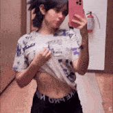 a woman is taking a picture of herself in a mirror with the word x on the bottom