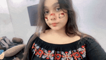 a girl with hello kitty on her face and a bandage on her nose