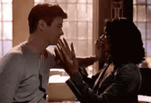a man and a woman are standing next to each other in a room .