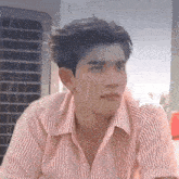 a man in a striped shirt is sitting in the rain .