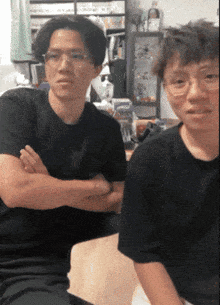 a man with his arms crossed is sitting next to another man