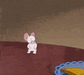 a cartoon of tom and jerry sitting on top of a table with a plate of fruit .