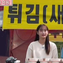 a woman is standing in front of a yellow sign that says ' i 'm a foreigner ' on it .