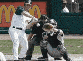 a baseball player is swinging at a ball in front of a mcdonalds sign