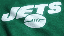 a green shirt with the word jets and a football