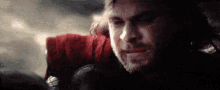 a close up of a man 's face with a beard and a red shirt .
