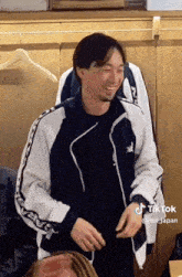 a man wearing a blue and white jacket has a tiktok account