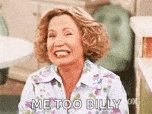 a woman is laughing and saying `` me too billy '' while wearing a floral shirt .