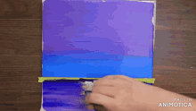 a person is painting a blue and purple painting with the words made in animatica visible