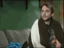 a man is sitting on a couch with a bandage on his face