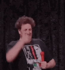 a man is giving a thumbs up while holding a microphone in his hand .