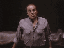 a man in a gray shirt is standing in front of a mummy and making a funny face .