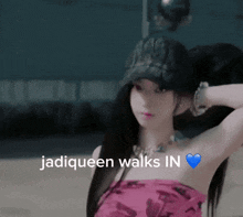 a woman wearing a hat with the words jadiqueen walks in written on it