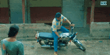 a man is sitting on a motorcycle with hk written on the bottom