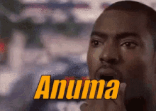 a close up of a man 's face with the word anuma written in yellow