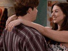 a man and a woman are hugging each other and the woman is smiling