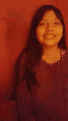 a young girl with long hair is smiling for the camera