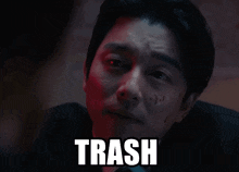 a man in a suit and tie is making a face with the word trash above him