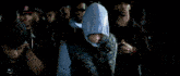 a woman in a blue hoodie is pointing at something in the dark