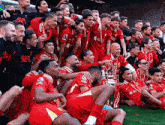 a group of soccer players are posing for a picture with the trophy