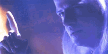 a close up of a person 's face with a blue light behind him .