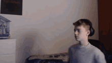 a young boy wearing headphones stands in front of a wall that says that matters
