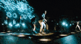 a group of people are dancing on a stage in front of a screen that says svcineth