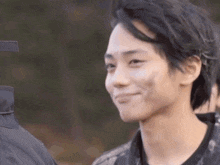 a close up of a young man 's face with a smile on his face .
