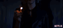 a woman is holding a lit match in her hand and netflix is visible in the corner