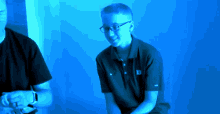 a boy wearing glasses and a wilson polo shirt smiles