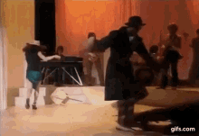 a man and a woman are dancing on a stage with a band behind them .