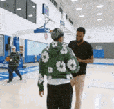 a man in a green hoodie is talking to another man