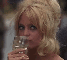 a woman is drinking from a wine glass with her mouth open