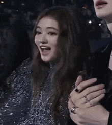a woman is holding a man 's hand and making a funny face while sitting in a stadium .