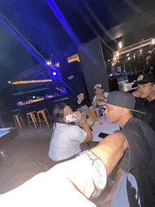 a group of people sitting at a table with a man wearing a watch that says " o " on it