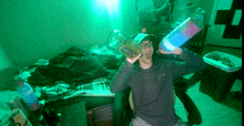 a man in a room with a bottle of aqua on the floor