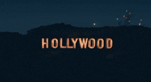 two women standing in front of the hollywood sign