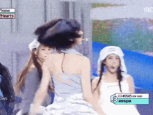 a group of girls are performing on a stage and one of them is wearing a white hat .
