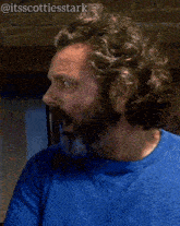 a man with a beard is wearing a blue shirt and has the hashtag @itsscottiesstark on the bottom right
