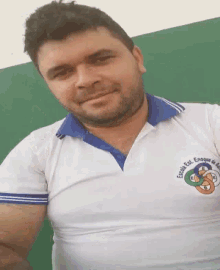 a man with a beard wears a white shirt that says escola est. enrique de souza