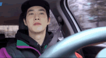 a man wearing a hat is driving a car with the number 1 in the background