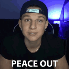a young man wearing a yankees hat and a black shirt says peace out