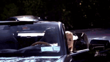 a woman is sitting in a black convertible with abc hd written on the side