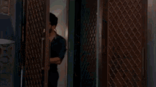 a man and a woman are standing next to each other in a doorway holding hands .
