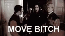 a group of men are standing next to each other in a room with the words `` move bitch '' written on the bottom .