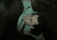 a man in a white shirt and black tie is hanging upside down