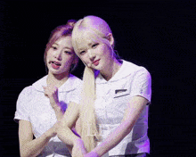 a couple of girls standing next to each other with the letter l on the bottom left