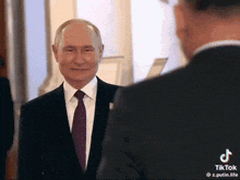 a man in a suit and tie is standing next to another man in a suit and tie
